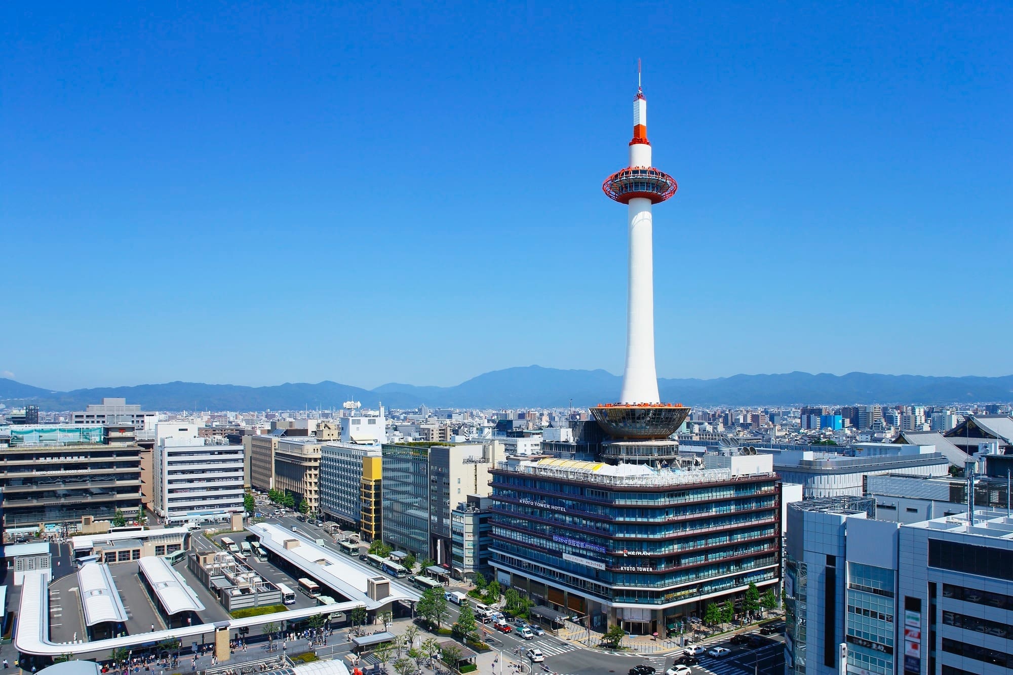 Blogs 14 Kyoto Tower standing prominently above the surrounding buildings in Kyoto, Japan, against a clear blue sky.