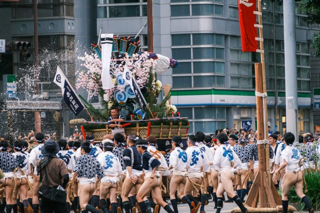 Top 8 Unforgettable Festivals in Osaka You Must Experience 5 a group of people walking down a street next to tall buildings stockpack unsplash